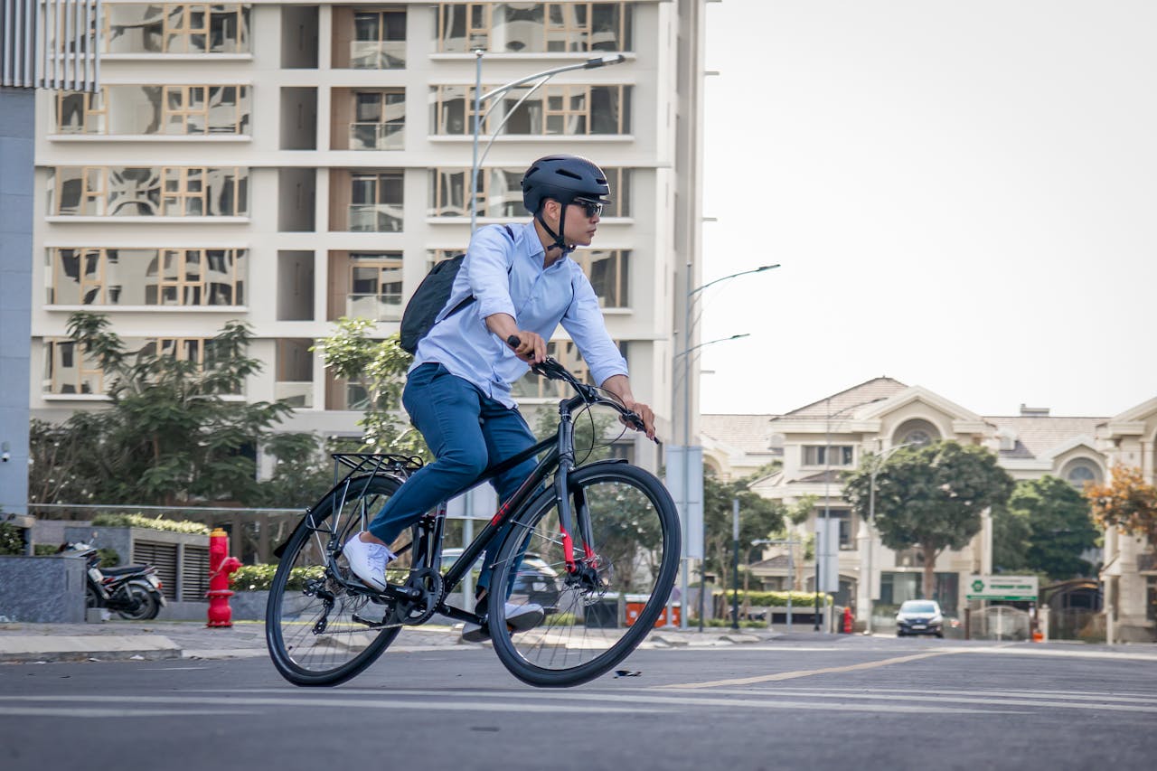 Home Man biking through an urban street in Ho Chi Minh City, wearing a helmet and casual attire.