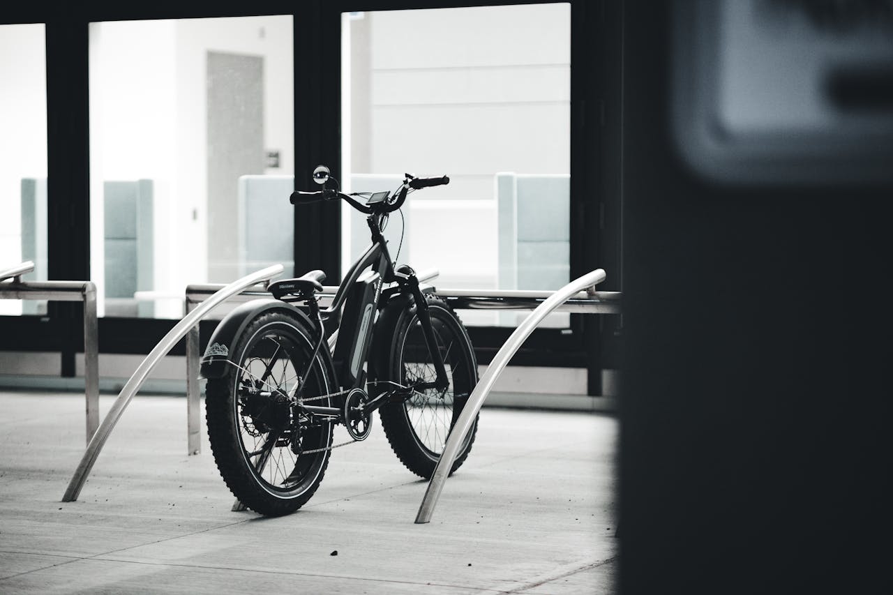 Home Black and white image of an electric bicycle parked indoors in an urban environment.